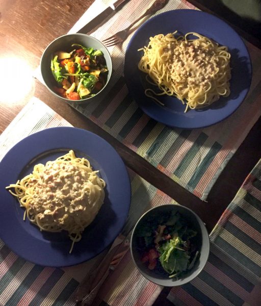 Spaghetti speciale: Zwei Teller mit Nudeln und Carbonara-Sauce und Salatschälchen