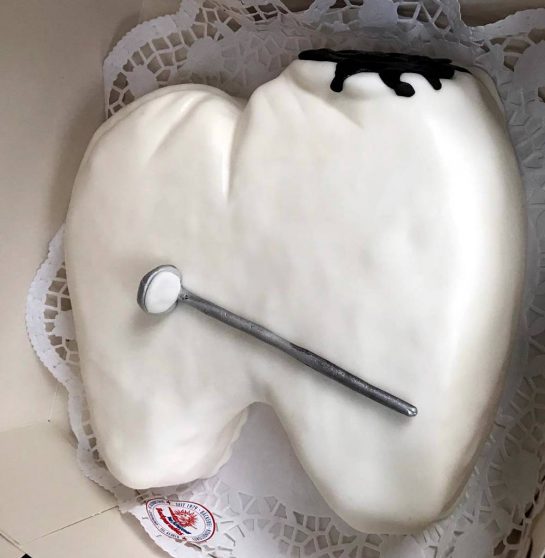 Kuchen in Form eines Zahns mit einem Mundspiegel