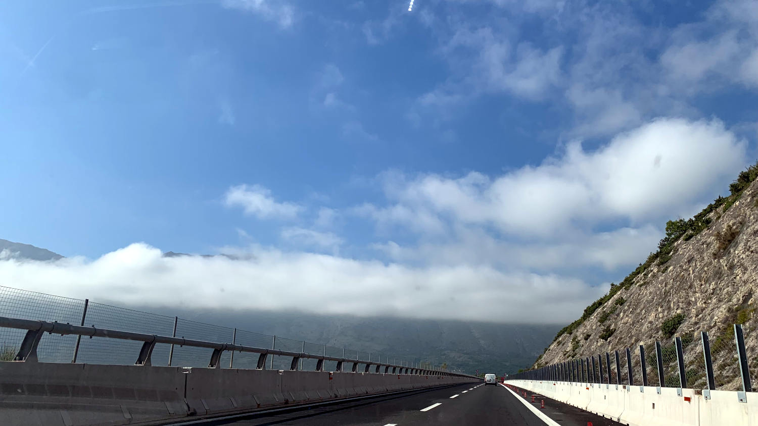 Autobahn zwischen Bergen und tief hängenden Wolken