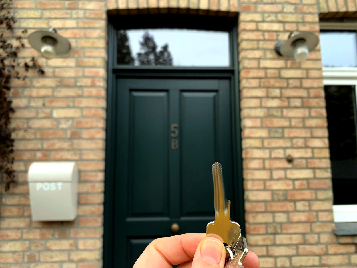 Schlüssel vor Haustür, Hauswand mit Backsteinen