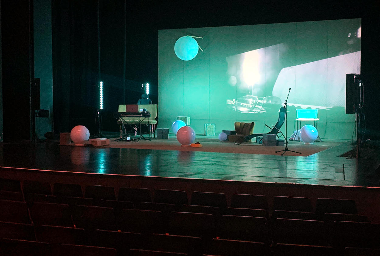 Bühnenbild im Theater Marl: Sessel und Lichtkugeln, dahinter eine Leinwand