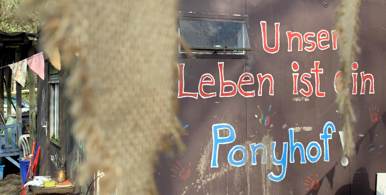 Die Worte "Unser Leben ist ein Ponyhof", gemalt auf einen Bauwagen