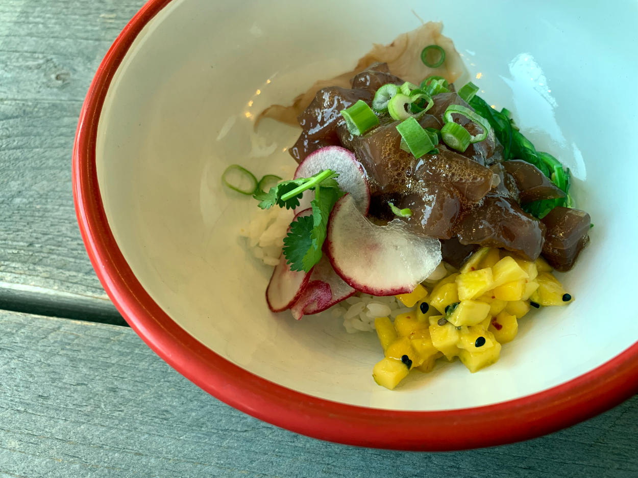 Poke-Bowl: Eine Schale mit Mango, frischem Thrunfisch, Reis und Radieschen