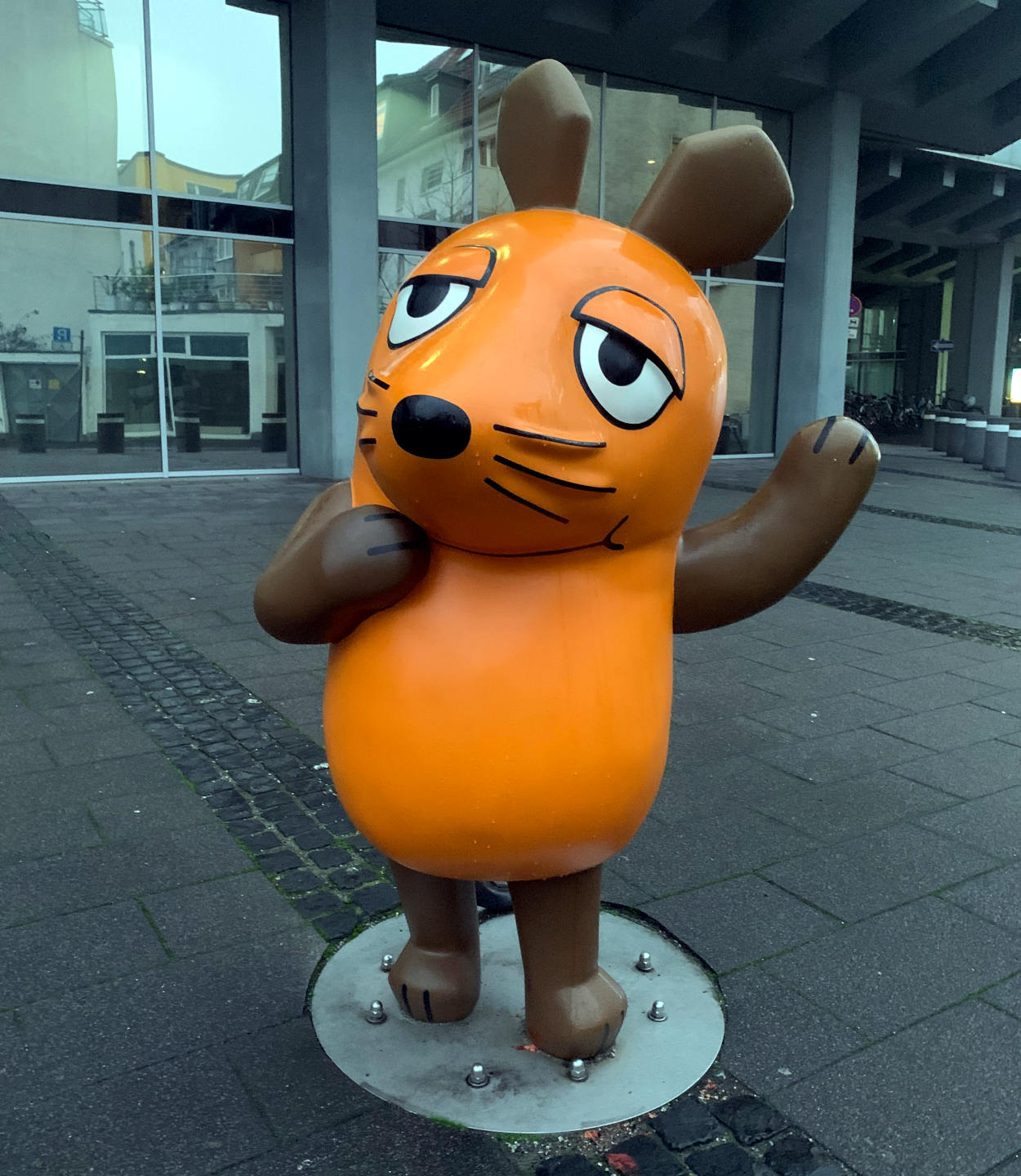 Die orangene Maus in der Kölner Innenstadt, dahinter ein Bürogebäude